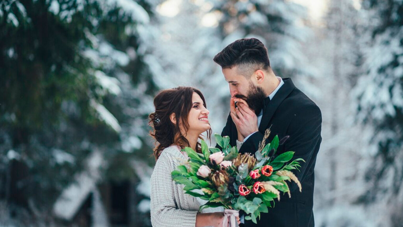 Qual o melhor mês para casar no Brasil? casal apaixonado se olhando enquanto se casa em um cenário com arvores congeladas e neve