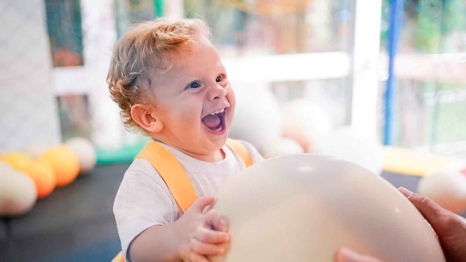 ideias de brincadeiras para festas infantis para bebês. com bebê se divertindo com uma bola