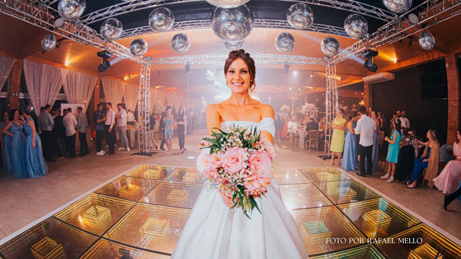 Tradições de casamento: as preferidas pelos casais Noiva na pista de dança com vestido tomara que caia segurando um buque com flores na cor rosa se preparando para jogar o buque.